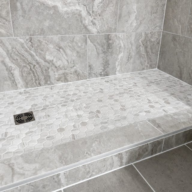 Marble-look porcelain shower with a hexagon mosaic floor